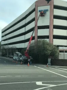 Building wall sign repair and installation with bucket truck by General Sign Service Corporation.