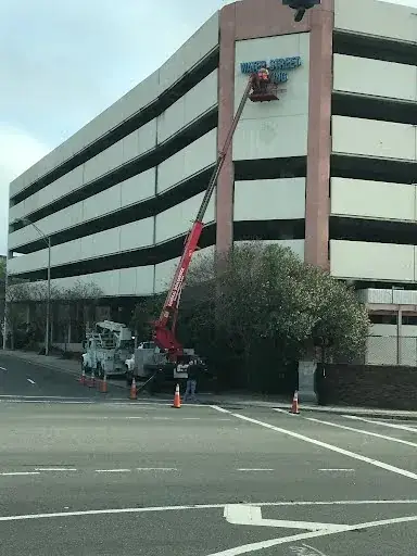 Unbeatable Ways General Sign Service Corporation Mastered Jacksonville High Rise Sign Repair After Severe Storms 1 Building wall sign repair and installation with bucket truck by General Sign Service Corporation.